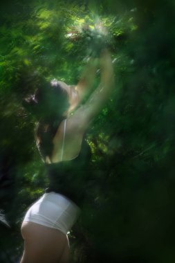 Genç bir model, kelebeklerin gururlandırıcı uçuşunu sembolize etmek için birden fazla pozunu verir. Sırtında kelebek danteli olan siyah bir bluz giyer..