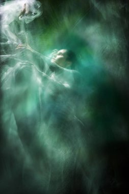 Çift pozlu örgü kostümlü bir dansçı başının üstünde beyaz bir duvak taşıyor..