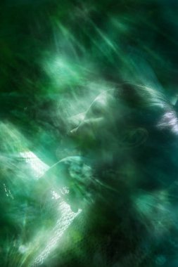 Parlak tropikal yaprak dokularıyla dans eden genç bir kadının yüz görüntüsü..