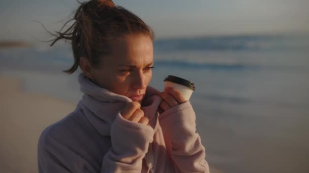 穿着舒适的毛衣 晚上在海滩喝咖啡的中年妇女压力很大 — 图库视频影像