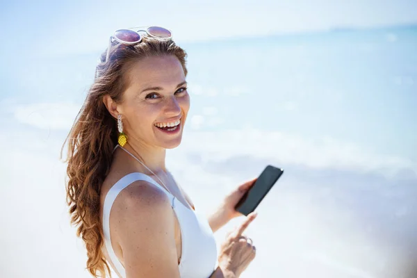 Porträt Einer Lächelnden Modernen Frau Strand Weißer Badebekleidung Die Smartphone — Stockfoto