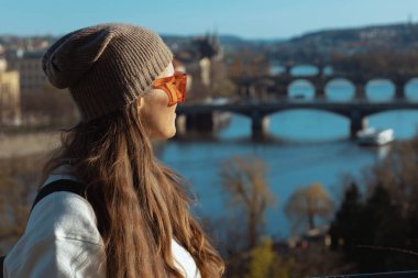 Prag 'da beyaz kazaklı, şık, yalnız bir turist kadın yürüyüş turu yapıyor..