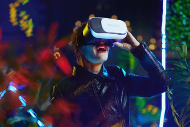 40 yaşında, video gözlüklü, metaverse giymiş bir kadın..