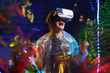 VR gözlüklü neşeli stil sahibi kadın sanal gerçeklikle eğleniyor..