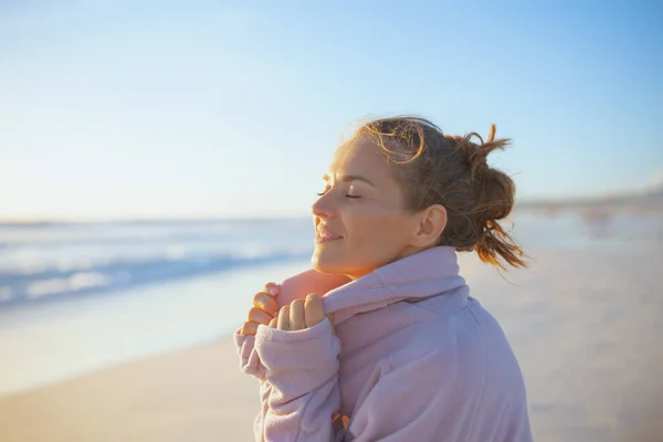 リラックスしたエレガントな中年の女性で居心地の良いセーターでビーチで夜リラックス — ストック写真