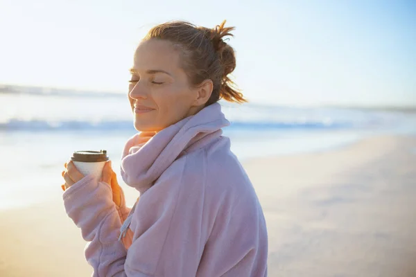 傍晚时分 穿着舒适的毛衣 在海滩喝茶的优雅优雅女人 — 图库照片