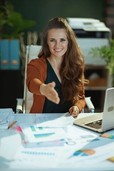 現代の緑のオフィスで現代の中小企業経営者の女性が握手のために手を伸ばし — ストック写真