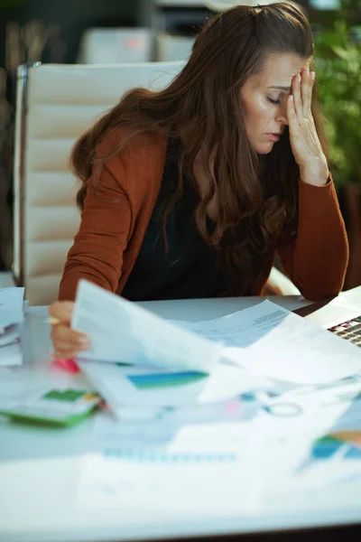 疲れてトレンディーな小さなビジネスの所有者の女性は 現代の緑のオフィスで文書を扱う — ストック写真