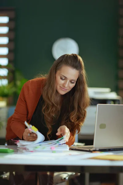 スタイリッシュな中年中小企業の所有者女性とノートパソコンの作業で現代の緑のオフィス — ストック写真