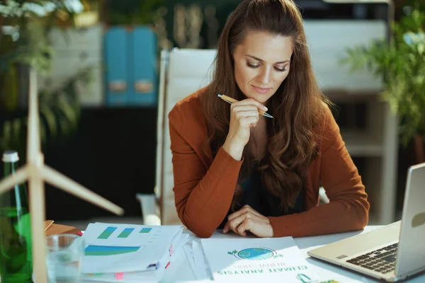 トレンディーな40歳の中小企業経営者の女性は 現代の緑のオフィスで文書を扱う — ストック写真