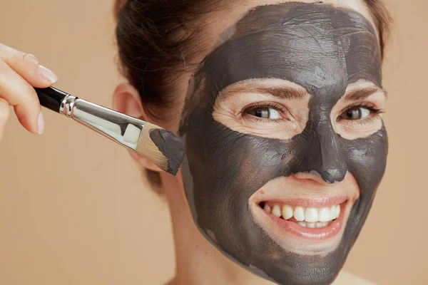 Gelukkig Modern Vrouw Met Borstel Cosmetische Masker Geïsoleerd Beige Achtergrond — Stockfoto