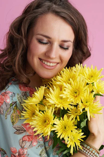 穿着花裙子 开着黄色菊花花的快乐而时尚的女人 花朵是粉红色的 — 图库照片