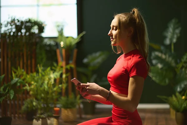 Сучасна Жінка Червоному Фітнес Одязі Сучасному Зеленому Будинку Робить Йогу — стокове фото