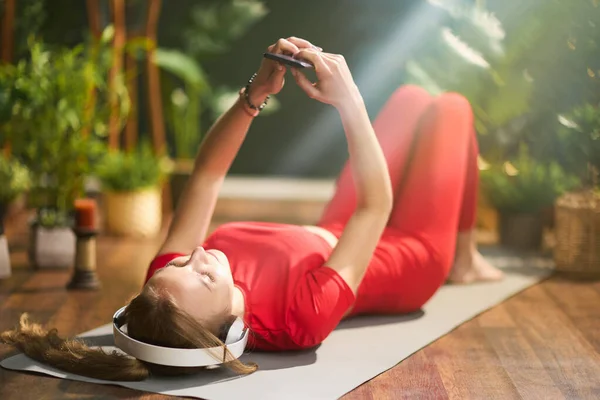 Giovane Donna Abiti Fitness Rossi Con Tappetino Yoga Utilizzando Smartphone — Foto Stock