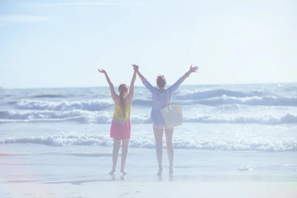 从身后看到现代母亲和少女在海滩上欢欣鼓舞 — 图库照片