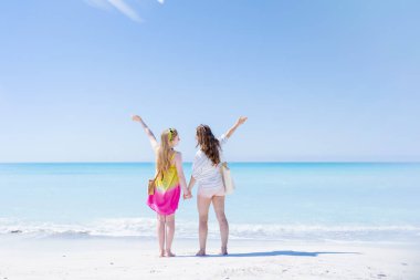 Sahilde neşe içinde modern anne ve genç kızı gördüm..