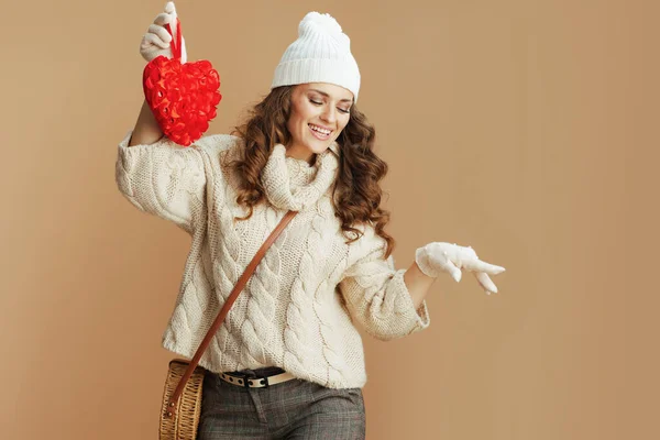 겨울아 베이지 스웨터를 하트와 핸드백을 베이지 배경에 고립된 여성이 — 스톡 사진