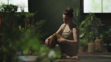 modern 40 years old woman with yoga mat stretching in the modern green house.