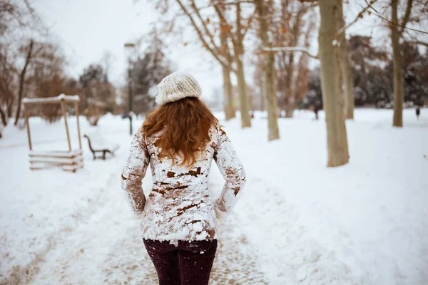 겨울에는 밖에서 모자를 스카프를 여성의 뒤에서 겨울에는 눈덮인 양가죽 코트를 — 스톡 사진