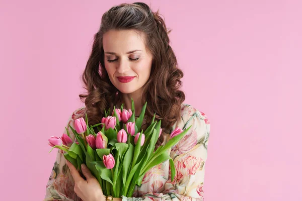リラックスしたスタイリッシュな40歳の女性で花のドレスとともにチューリップ花束ピンク — ストック写真