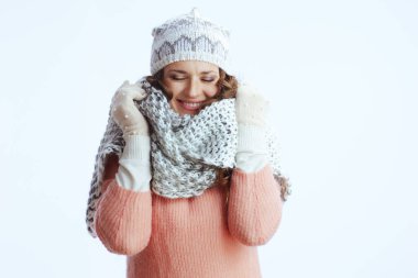 Merhaba kış. Gülümseyen modern kadın kazak, eldiven, şapka ve eşarp ile sarılı beyaz bir eşarp.