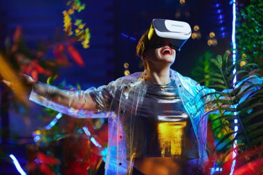 Gülümseyen modacı 40 yaşındaki kadın sanal gerçeklikte VR gözlükleriyle seviniyor..