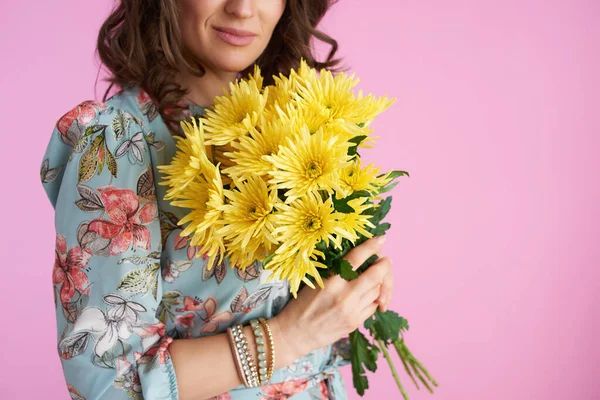 中年妇女的衣服 长长的波浪般的黑发 黄色菊花 粉红色背景下的花朵 — 图库照片