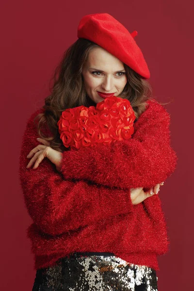 情人节快乐 穿着红色毛衣和贝雷帽 红心拥抱红心的沉思的40岁现代妇女 — 图库照片