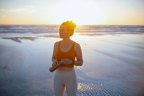 Entspannte Aktive Sportlerin Sportkleidung Mit Wasserflasche Strand Bei Sonnenuntergang — Stockfoto