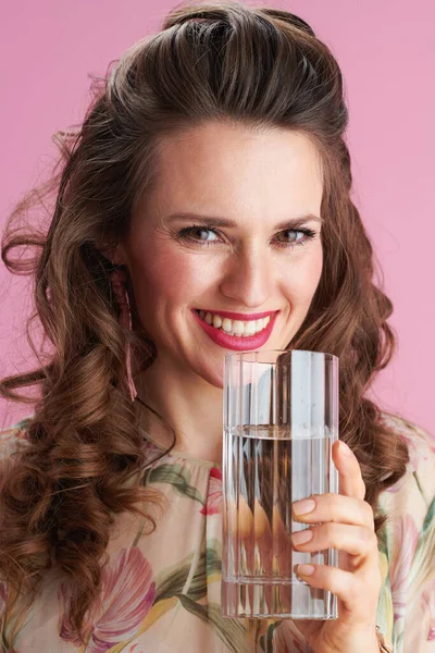 Portret Uśmiechniętej Letniej Kobiety Kwiatowej Sukience Szklanką Wody Różowym Tle — Zdjęcie stockowe