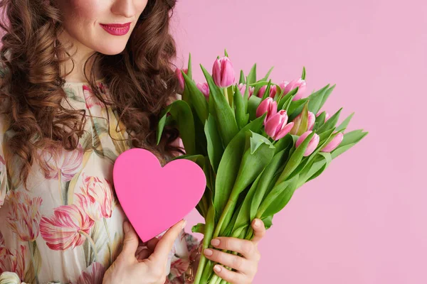 ピンクの背景に隔離されたチューリップの花束とピンクの心を持つ女性の閉鎖 — ストック写真