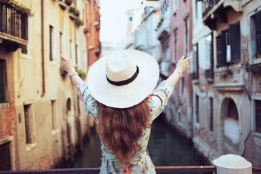 Venedik, İtalya 'da şapkalı, çiçekli elbiseli orta yaşlı bir gezgin kadın gördüm..