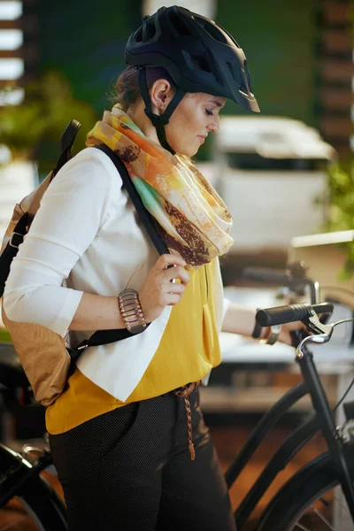 modern 40 years old business woman in bike helmet with bicycle in modern eco office.
