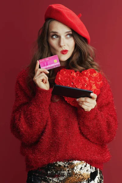情人节快乐 穿着红色毛衣 头戴红心贝雷帽 头戴红心 头戴智能手机 头戴信用卡 沉默寡言的现代女性在网上购物 — 图库照片