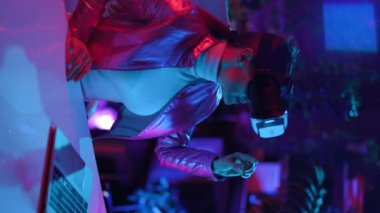 Neon metaverse futuristic concept. stylish business woman in virtual reality goggles on dark background.