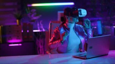 Neon metaverse futuristic concept. stylish business woman in virtual reality goggles on dark background.