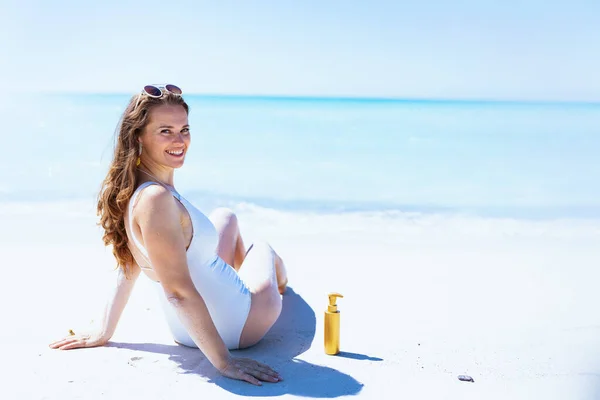 Gülümseyen Yaşında Beyaz Mayo Giymiş Kumsalda Oturan Bir Kadın — Stok fotoğraf