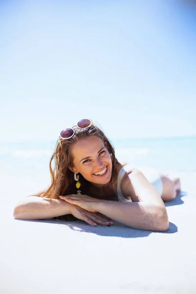 微笑着躺在海滩上的40岁的现代女人 — 图库照片