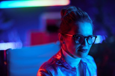 Neon metaverse futuristic concept. Portrait of modern business woman in glasses in modern office.