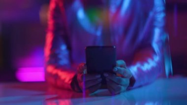 Neon metaverse futuristic concept. Closeup on business woman using smartphone applications in office.
