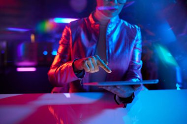 Neon metaverse futuristic concept. Closeup on business woman with tablet PC in office.