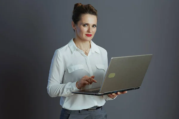 Trendy Middle Aged Woman Employee White Blouse Laptop Grey Background — Stok fotoğraf