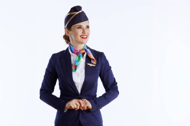 happy elegant female flight attendant isolated on white background in uniform looking at copy space. clipart