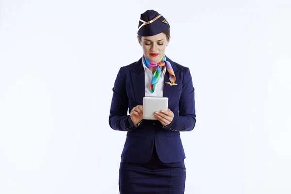 modern air hostess woman isolated on white background in uniform with tablet PC.