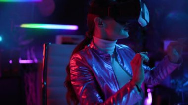 Neon metaverse futuristic concept. happy stylish 40 years old woman in virtual reality goggles working in metaverse.