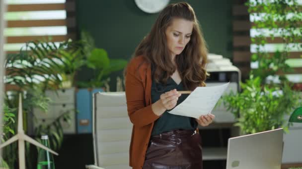 在现代绿色办公室里 年轻的小企业主女人带着笔记本电脑 带着文件工作 心事重重 — 图库视频影像