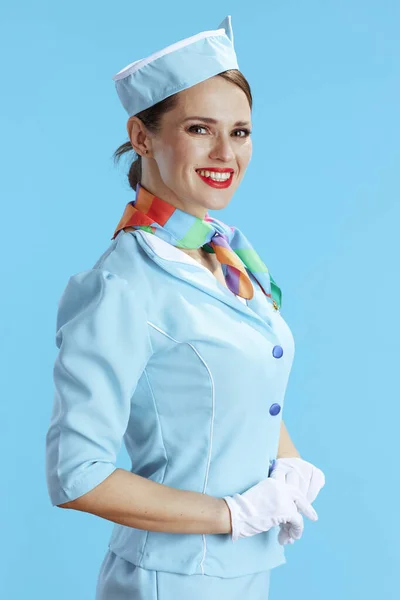 smiling modern air hostess woman on blue background in blue uniform.