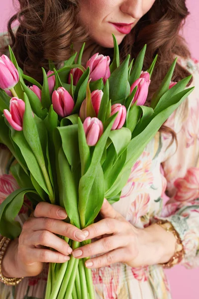 中年妇女用郁金香花束与粉红隔离的衣服 — 图库照片