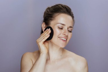 Mavi arka planda pamuk yastıklı mutlu orta yaşlı kadın..