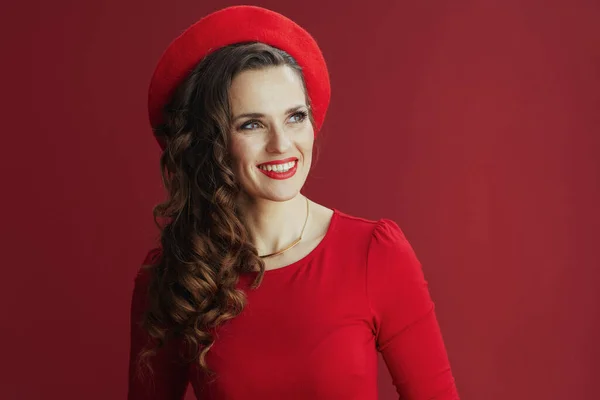 ハッピーバレンタイン 赤いドレスと赤い背景のベレー帽の長い波状の髪を持つ幸せなエレガントな女性 — ストック写真